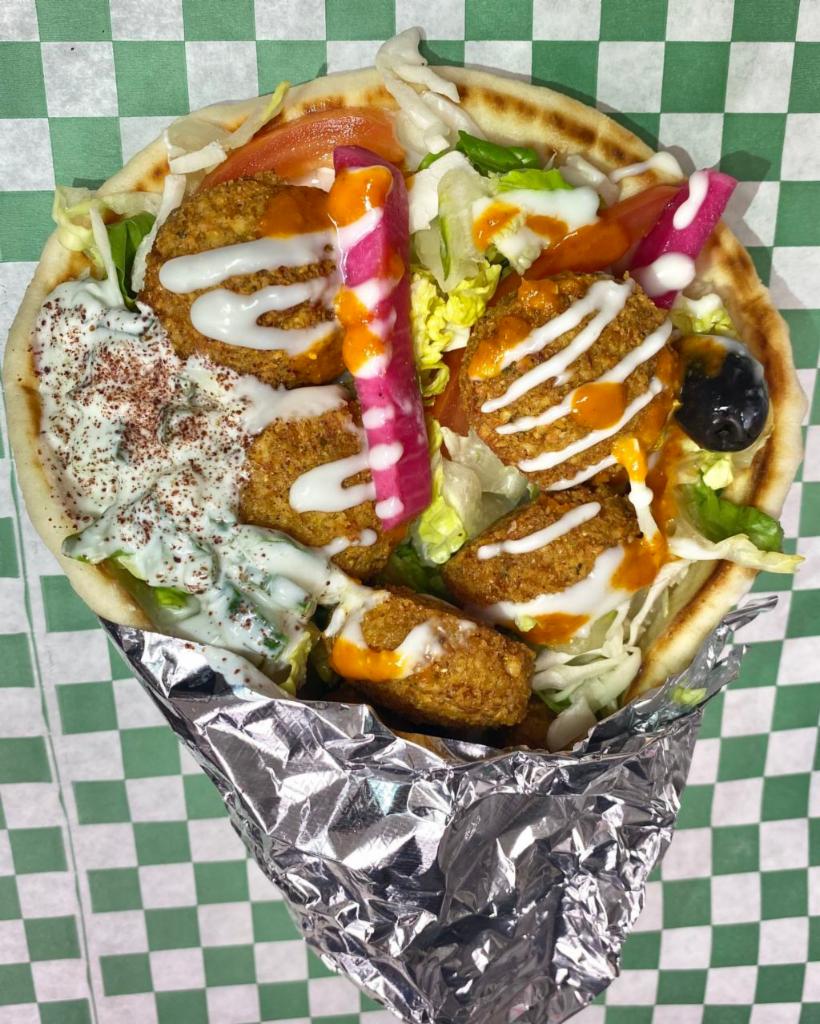 4. Falafel Gyro · Our falafel is made from scratch with garbanzo beans and spices served in hot pita bread. Served with Tomatoes, lettuce onions, green peppers. House-made sauces tzatziki, garlic, and hot sauce.