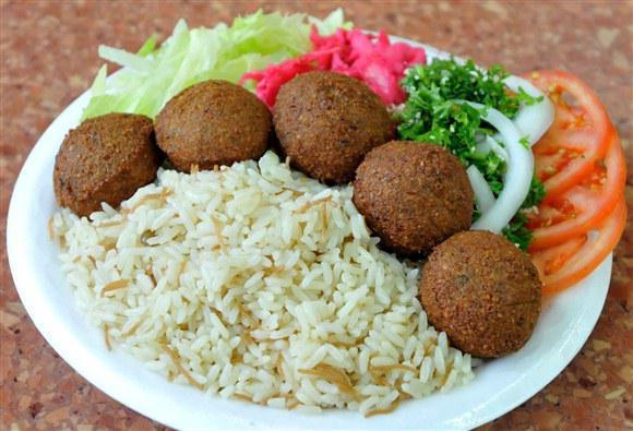 Falafel Plate Over Rice (Vegetarian & Vegan)  · Our falafel is made from scratch with garbanzo beans and spices. 10 Falales served with rice, salad, pita bread, house tzatziki, and garlic sauce. Ask us to make it Vegan! 