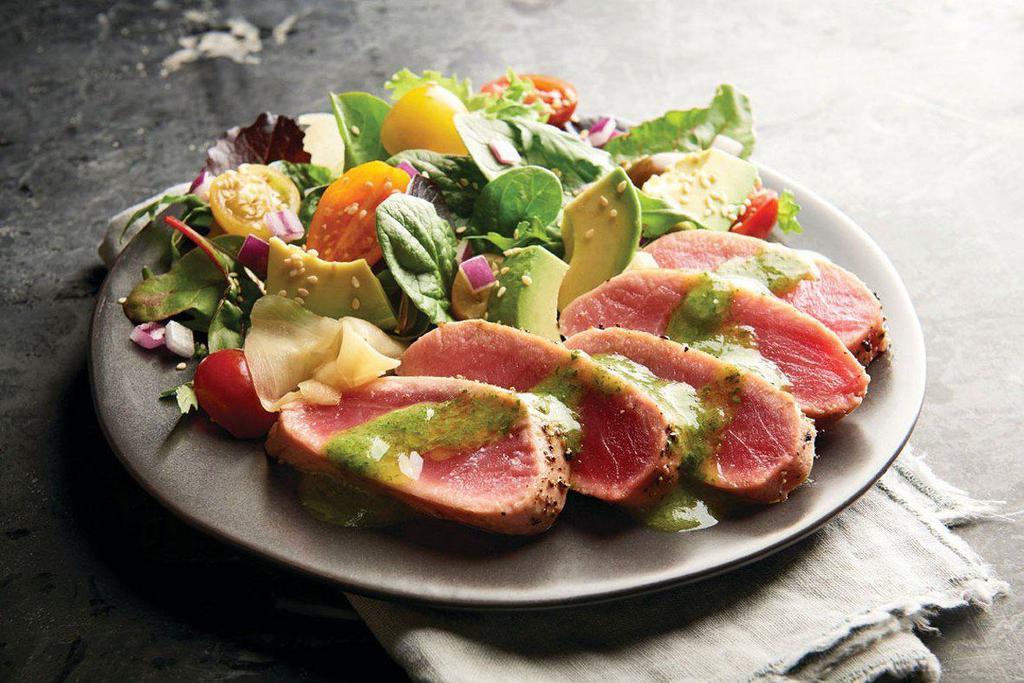Seared Tuna Salad · Savory mixed greens, rare ahi tuna, grape tomatoes, avocado, sesame seeds, and cilantro-lime vinaigrette.