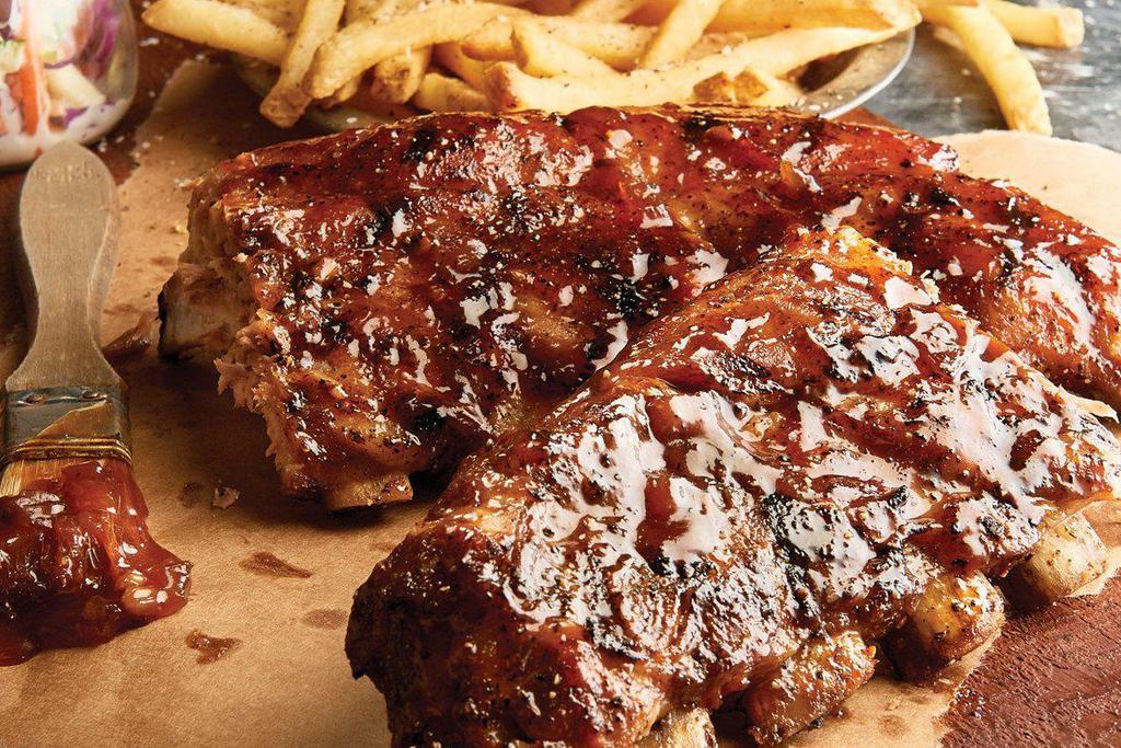 Brick House Famous BBQ Ribs · Pork loin Texas ribs, beer-braised, and slow smoked with house-made whiskey barbeque sauce. Served with side of creamy coleslaw and fries.