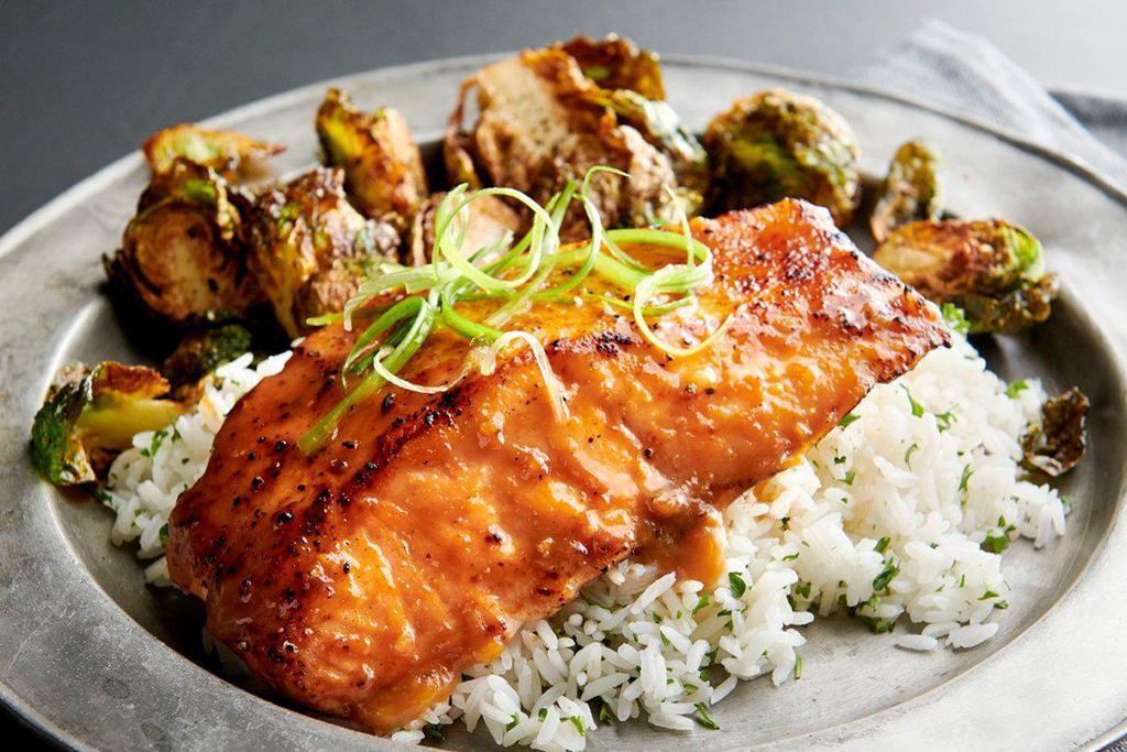 Miso Glazed Salmon · Marinated and grilled Atlantic salmon fillet topped with a sweet and savory miso glaze. Served with cilantro-lime rice and crispy brussels sprouts.