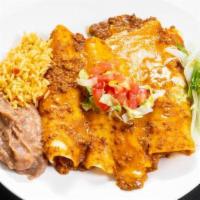 Beef Enchiladas · Corn tortillas filled with ground beef, topped with chili con carne and cheese. All served w...