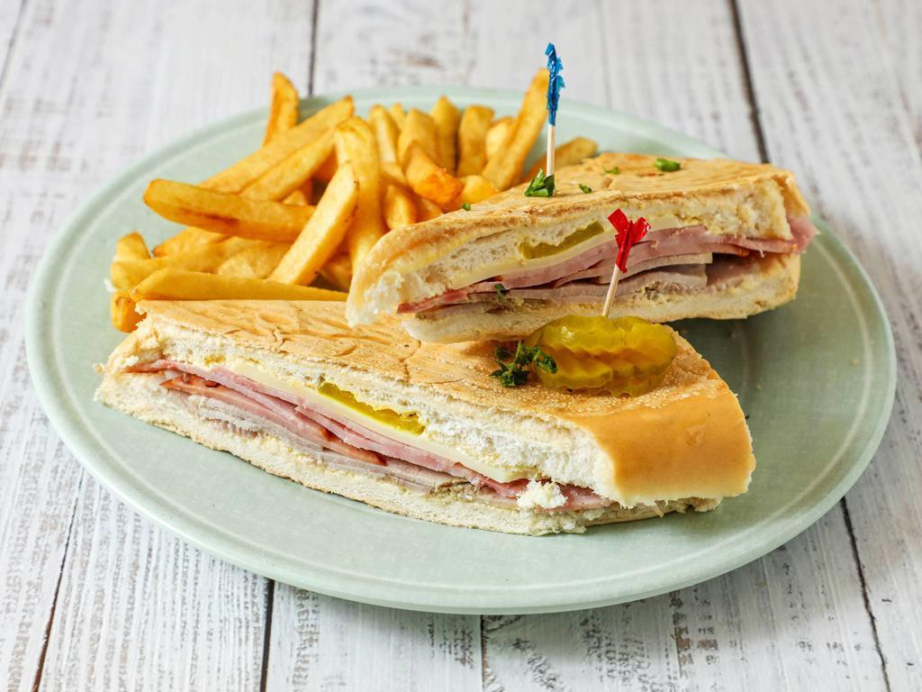 Cuban sandwich · Cuban Sandwich toasted with butter panini style with sliced ham, pork, Swiss cheese, & Pickles. 