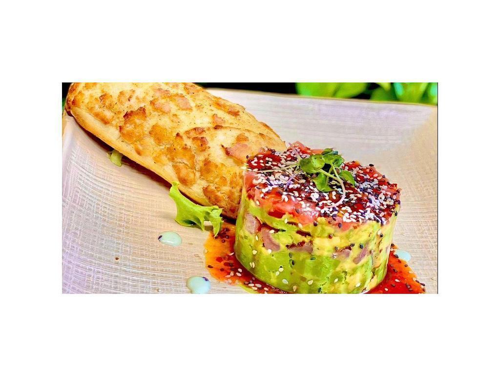 Tuna Tartare · Ahi tuna topped with fresh avocado, drizzled with sweet chili sauce, cucumber cusabi, and sesame seeds