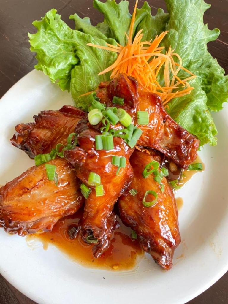 CHICKEN WINGS TAMARIND · Deep-fried chicken wings mixed tamarind sauce top sliced green onions.
