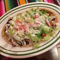 Huarache · Oval shaped corn tortilla topped with your choice of meat, beans, lettuce, tomato, sour crea...