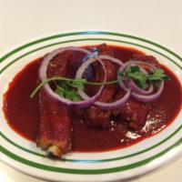 Costillas en Salsa Verde o Roja · Pork ribs in green or red sauce.  Accompanied with corn tortillas, rice and beans.