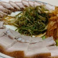Bossam · Succulent slow boiled pork belly, served with a sweet & spicy radish salad, white kimchi, ra...