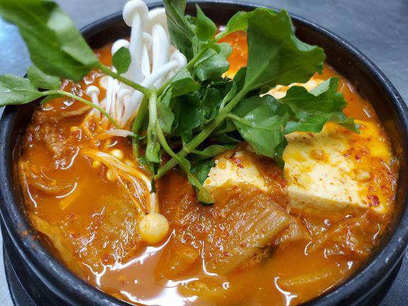 Kimchi Jjigae · Kimchi stew with tender pork morsels, rice cakes, and firm tofu, ubiquitous with Korean cuisine. Very popular item.