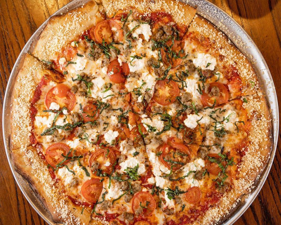 BBC Rustic Pizza · Ricotta cheese, red sauce, Italian sausage, chopped tomato, fresh basil. Finished with crushed red pepper, Italian seasonings and a Parmesan crust