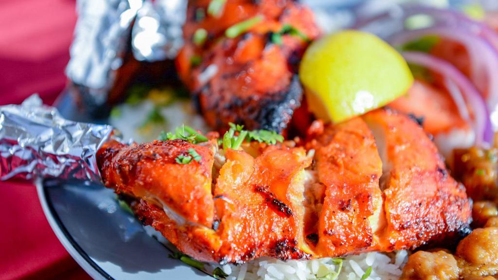 Tandori (Oven) Chicken - Half · Chicken marinated in yogurt, ginger, garlic and house spices. Grill in Tandoor ( Mud Oven). Served with white basmati rice, salad, side chickpeas, one naan bread and sauces