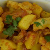 21. Aloo Gobi Masala · Fresh cauliflower and potatoes sauteed with tomatoes, onions and house spices. Served with b...