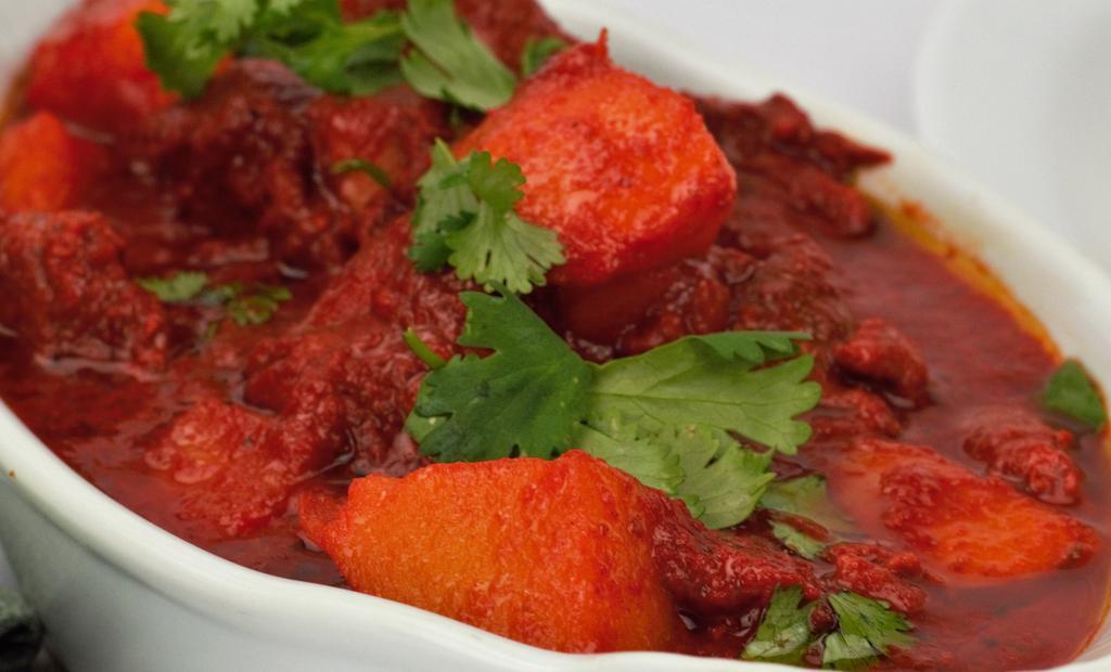 44. Lamb Vindaloo · Lamb and potatoes cooked in fiery hot sauce and house spices. Served with basmati rice.