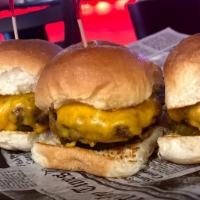 Beef Sliders · 3 well-done beef sliders topped with melted cheddar cheese, grilled onions and pickles.
