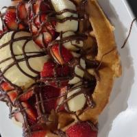 Tropical Pleasure Waffle · Belgian waffle, fresh strawberries & bananas, drizzled with chocolate syrup and a side of va...
