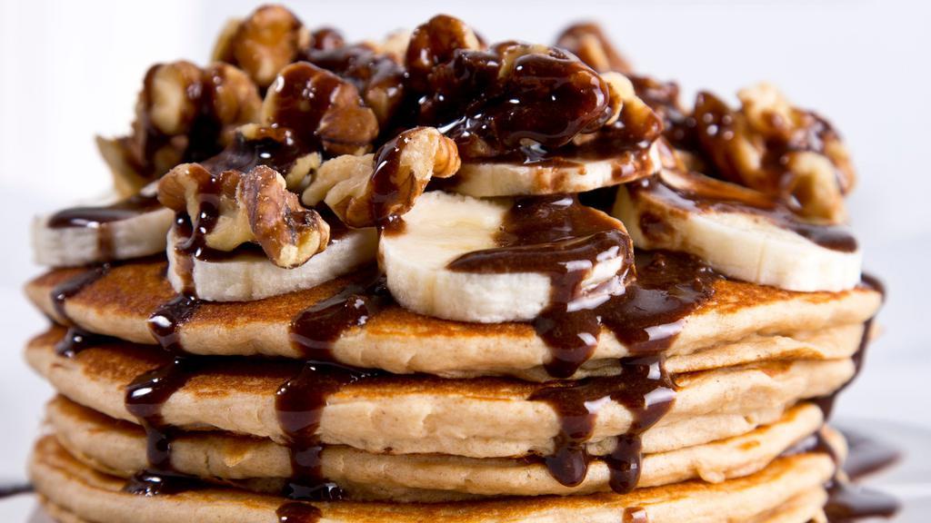 Chocolate Monster Pancakes · Non-GMO whole grain whey protein pancakes infused with dark chocolate chips and topped with bananas, walnuts, and sugar-free chocolate protein sauce.