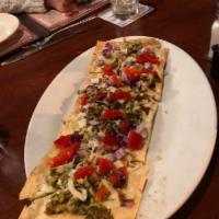 Garlic Pesto Chicken Flatbread · With mozzarella cheese, red onions, roasted red peppers and drizzled with our homemade balsa...