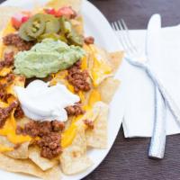Super Nacho · Tortilla chips topped with your choice of meat, cheddar cheese, tomato, guacamole, sour crea...