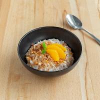 Coconut Rice Pudding · Creamy coconut rice pudding topped with toasted coconut and fresh orange slices. Vegan