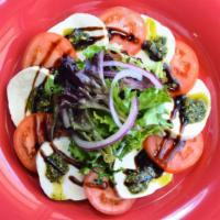 Caprese Salad · Fresh mozzarella, tomatoes, spring mix, thin sliced red onions, homemade pesto and balsamic ...