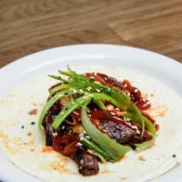 Korean Beef Taco · Marinated skirt steak, kimchee, Korean BBQ sauce, cilantro and sesame seeds.