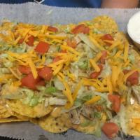 Chicken Cheese Nachos · Scattered tortilla chips covered with chili con queso and marinated diced chicken breast. Ga...