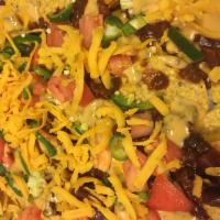 Chili Cheese Nachos · Scattered tortilla chips smothered with our house chili, covered with chili con queso then t...