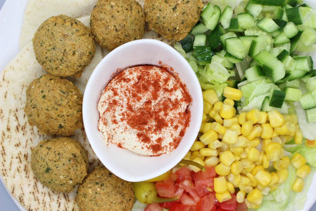 Falafel Plate · 6-8 falafels on a pita bread, next to our chopped salad with a side of hummus & extra tahini sauce.