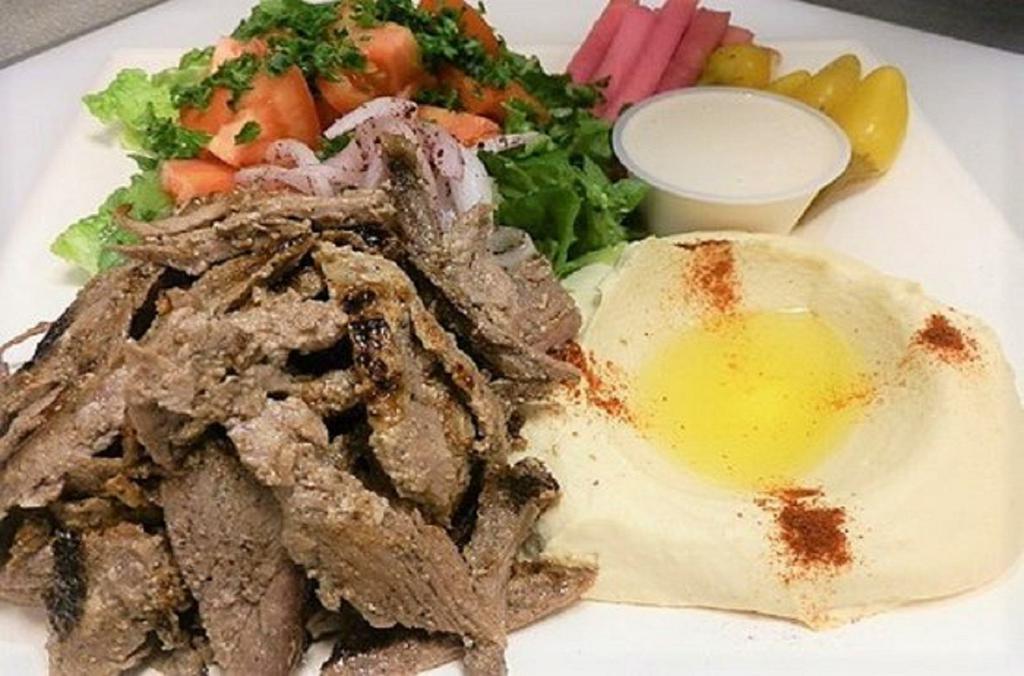 Tri Tip Shawarma Beef Plate · Marinated tri tip steak USDA choice cooked on vertical broiler then thinly sliced, served with hummus, tahini sauce, tomatoes, onions, pickles and pita bread.