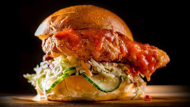 Crispy Spicy Chicken Sandwich · Crispy chicken sandwich topped with Chile-Lime Sauce and garnished with pickled cucumbers and slaw.