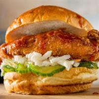 Crispy BBQ Chicken Sandwich · Crispy chicken sandwich topped with BBQ Sauce and garnished with pickled cucumbers and slaw.
