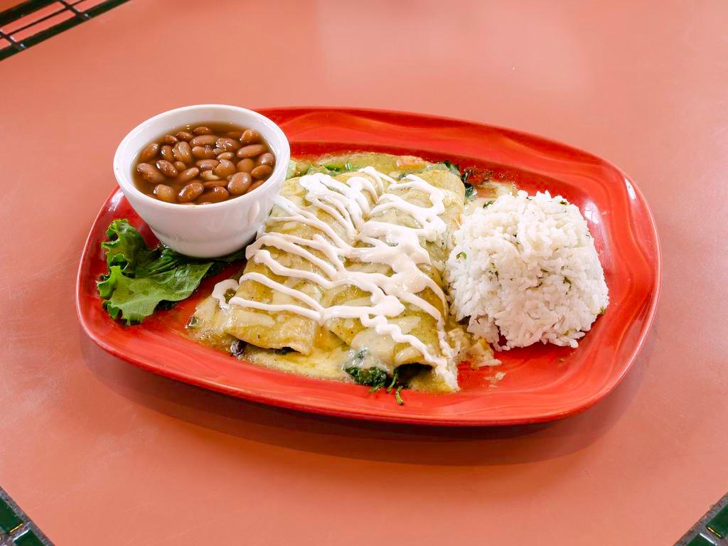 Enchiladas Espinaca · Spinach sauteed with mushrooms, onions, tomatoes, cilantro and jalapenos, rolled into 2 corn tortillas. Smothered with our verde salsa and topped with Jack cheese. Finished with crema Mexicana.