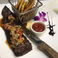 Churrasco · 12 oz. grilled steak topped with chimichurri. Served with tostones.