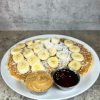 Banana Pancake Breakfast · 2 fluffy pancakes with raw walnuts inside, bananas and peanut butter on top. Includes maple ...