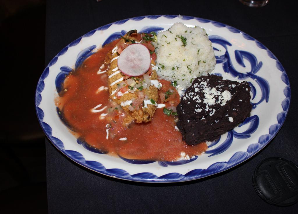 Chile Relleno · Roasted poblano pepper stuffed with oaxacan and Monterey Jack cheese, lightly fried and topped with tomato sauce. Served with cilantro rice and black beans. (Sonora). Vegan.