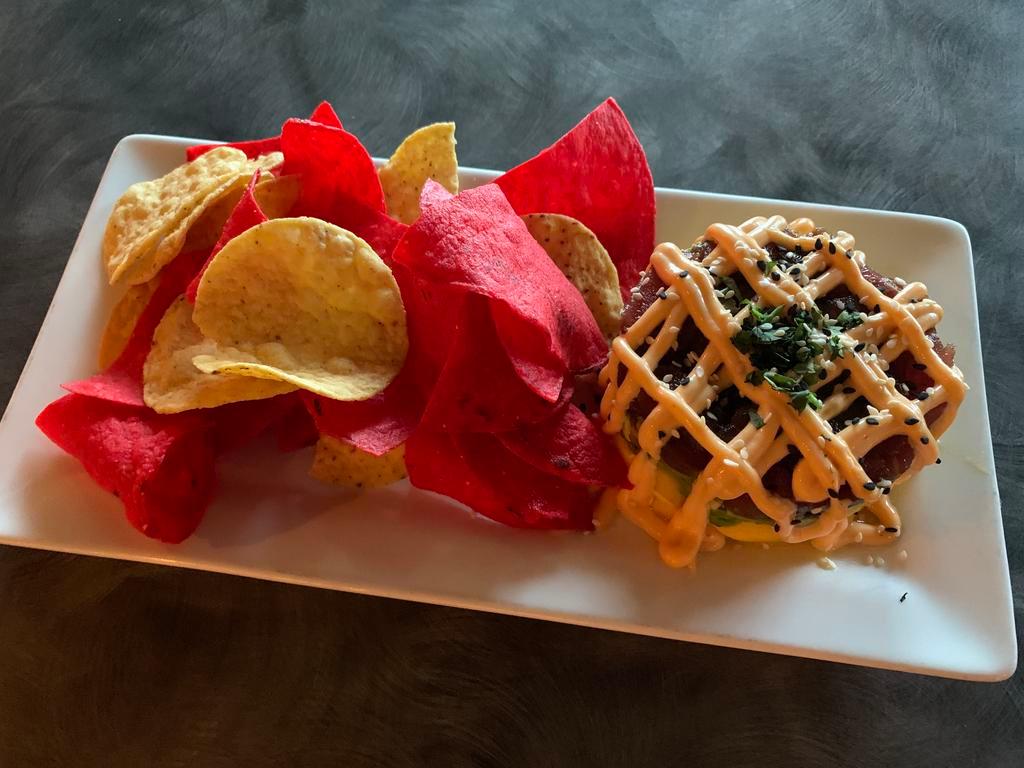 Ahi Tuna Poke Stack · Rare tuna, avocado, mango, sesame seeds, and green onions stacked and topped with a sriracha mayo. Served with tortilla chips.