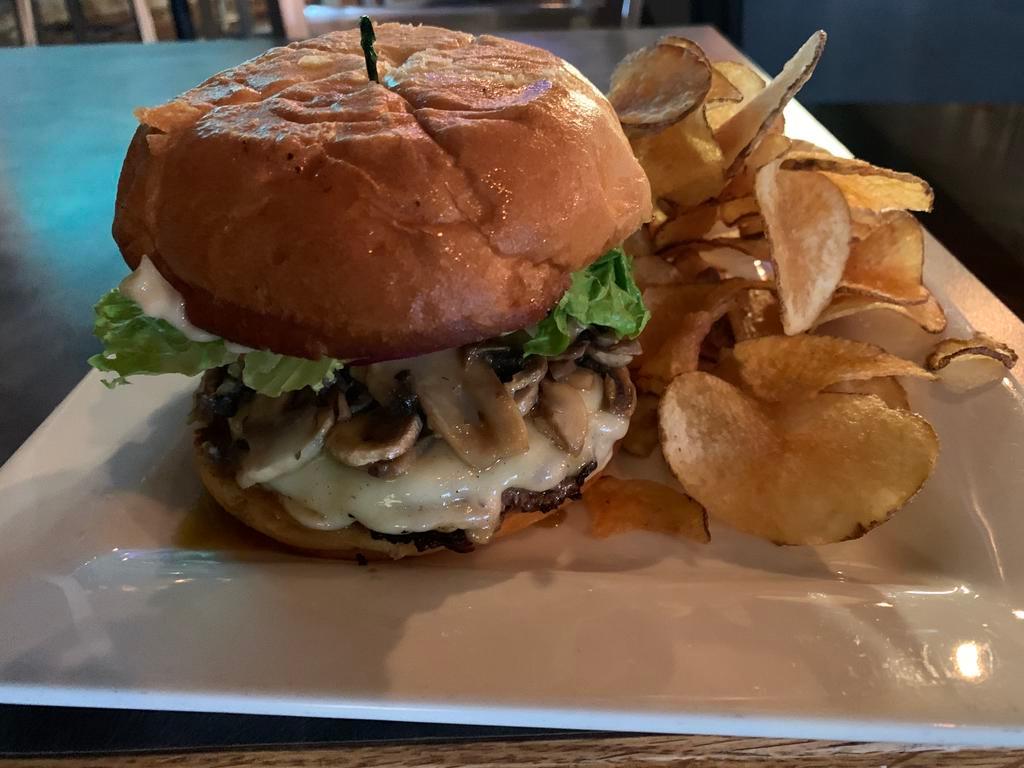 Mushroom Burger · Loaded with sauteed mushrooms and topped with Swiss cheese, tomatoes, crisp lettuce, red onions and mayo. A mushroom lover’s dream come true. Served on a brioche bun with fries or homemade potato chips.