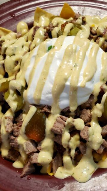 Smokehouse Nachos · A vowel generous amount of hand cut, fried and seasoned nacho chips with cheddar cheese, chili beans, jalapenos, and smoked chicken, topped with creole sauce and sour cream.