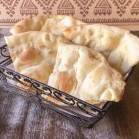 Naan · Tandoor fired white flour bread. Freshly prepared in our tandoor.