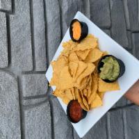 Chips with Guacamole, Queso and Salsa. · Crunchy tortilla chips served with sides of tomato salsa, cheddar cheese sauce, and guacamole.