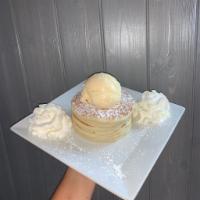 Plain Pancakes · A stack of our homemade pancakes, dusted with powdered sugar.  Comes topped with whipped cre...