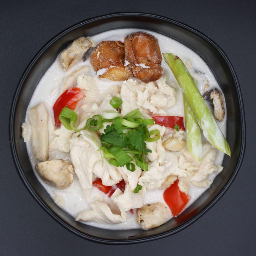 S2. Tom Kha Soup · Coconut soup and a hint of lime with mushroom, onion and bell pepper.