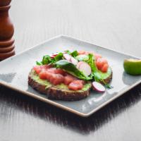 Ahi Tuna Avocado Toast · Served with Mediterranean quinoa, watercress, lime, and soy dressing.