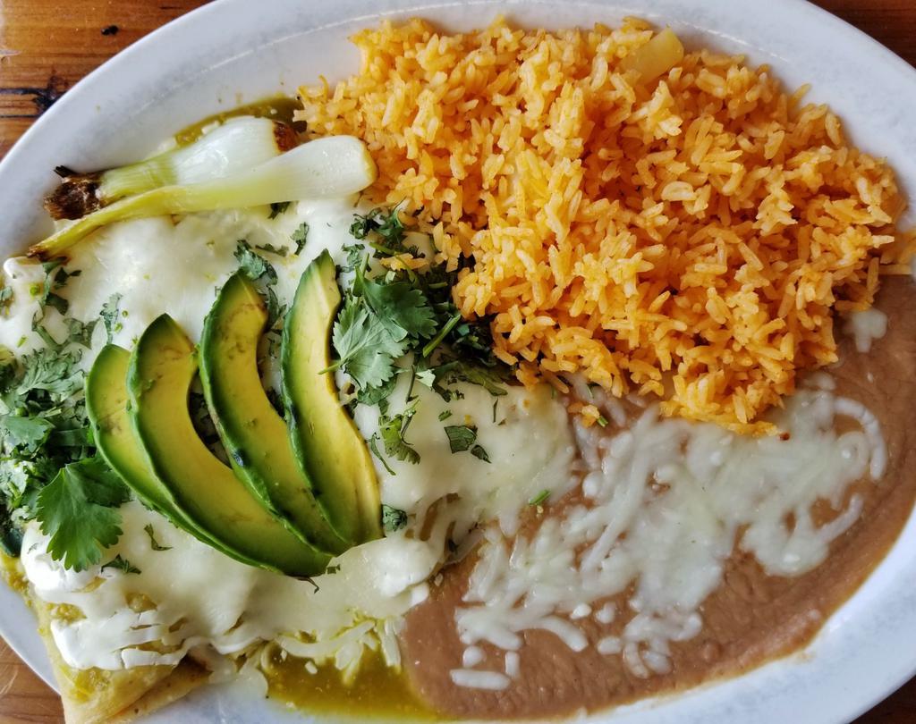 Enchiladas al Horno · Three tortillas filled with chicken, smothered in salsa verde topped with melted cheese, sour cream, grilled cambray onion, avocado and cilantro