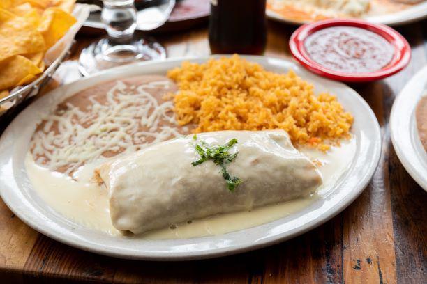 Burrito Plate · Extra large tortilla rolled with your choice of meat, cheese, rice & beans, then covered with queso. Served with rice & beans