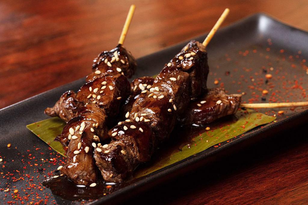 Skewers · Three skewers of seared fliet mignon or chicken cooked in sake teriyaki sauce; topped with sesame seeds and togarashi
