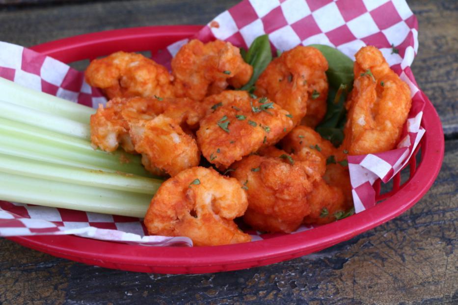 Cauliflower Wings · Gluten-free cauliflower bites battered and fried to a perfectly golden crisp, tossed in spicy buffalo or bbq sauce. Served with poblano ranch and celery sticks. 