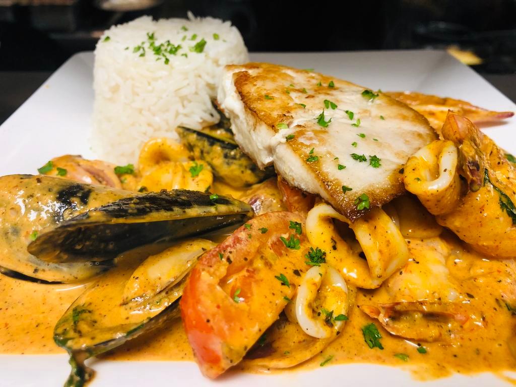 Seabass-Seafood a lo Macho · Pan seared fish of the day fillet mixed with seafood aji amarillo cream stew served with white rice.