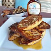 French Toast with Passion Fruit Maple Syrup · Soft baguette dipped in French toast batter paired with passion fruit maple syrup.