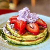 Matcha Green Tea Pancake · Served with matcha green tea glaze, fresh strawberries & ube whipped cream.